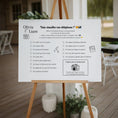 Charger l'image dans la visionneuse de la galerie, Affiche de jeu mariage « Fais chauffer ton téléphone ! » sur chevalet en bois, invitant les invités à relever des défis photos (selfie avec les mariés, danse folle, décor, photo de groupe…) avec cadre élégant et zone “Partagez vos photos” avec hashtag personnalisé.