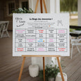 Charger l'image dans la visionneuse de la galerie, Panneau sur chevalet présentant un bingo de mariage avec une grille humouristique de moments à cocher pendant la fête, installé dans un lieu de réception bohème chic.
