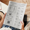 Charger l'image dans la visionneuse de la galerie, Personne tenant une gazette de mariage bohème ouverte sur une page en noir et blanc, affichant à gauche la liste des VIP (parents, témoins, demoiselles d’honneur et garçons d’honneur), un encadré “Partagez vos photos” avec une icône d’appareil photo et un QR code pour la liste de cadeaux, et à droite un programme horaire illustré des moments clés de la journée : arrivée, cérémonie, photos de groupe, vin d’honneur, dîner, gâteau et feu d’artifice.
