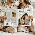 Charger l'image dans la visionneuse de la galerie, Couple assis côte à côte en pyjamas satinés couleur champagne, tenant une gazette des mariés classique ouverte avec en couverture leur photo enlacés au coucher du soleil et à l’intérieur un jeu de questions, des portraits croisés et un QR code pour des idées cadeaux.
