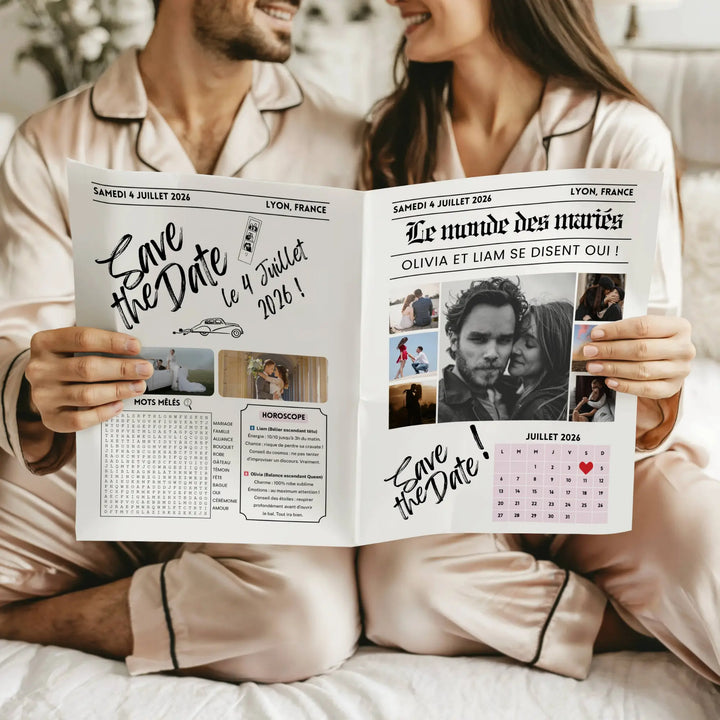 Couple assis côte à côte en pyjama satiné beige, souriant et feuilletant ensemble une gazette de mariage « Save the Date ».
