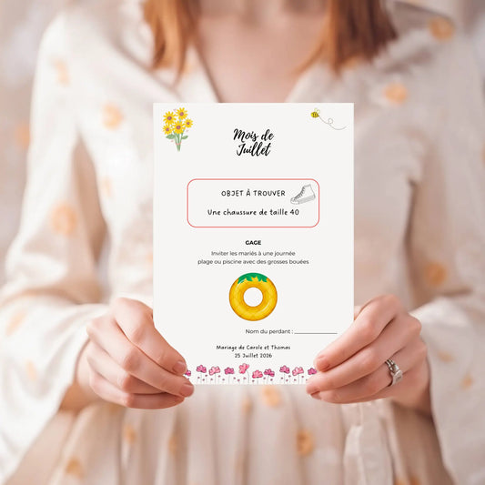 Carte du jeu des 12 mois mariage à imprimer : exemple mois de juillet avec objet à trouver et gage amusant pour animer la soirée des mariés