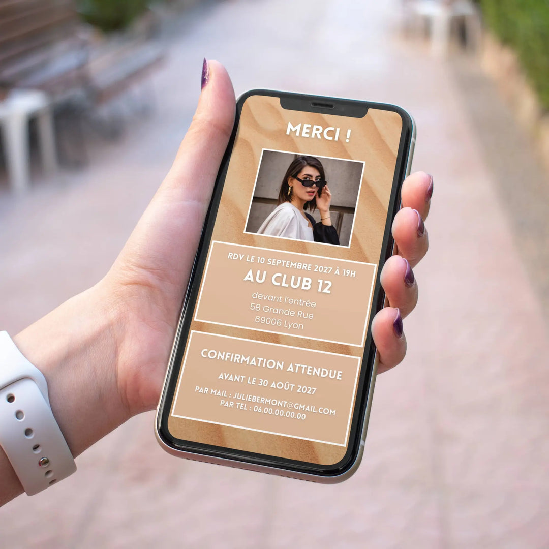 Main tenant un smartphone affichant l'écran de remerciement personnalisé de l'invitation digitale d'anniversaire 40 ans, avec photo, lieu du rendez-vous et date de confirmation.