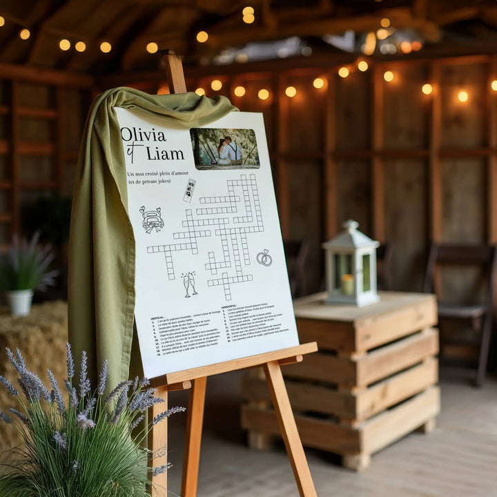 Panneau de mots croisés personnalisés  sur chevalet décoré lors d’un mariage champêtre, avec photo des mariés et ambiance guinguette en arrière-plan.